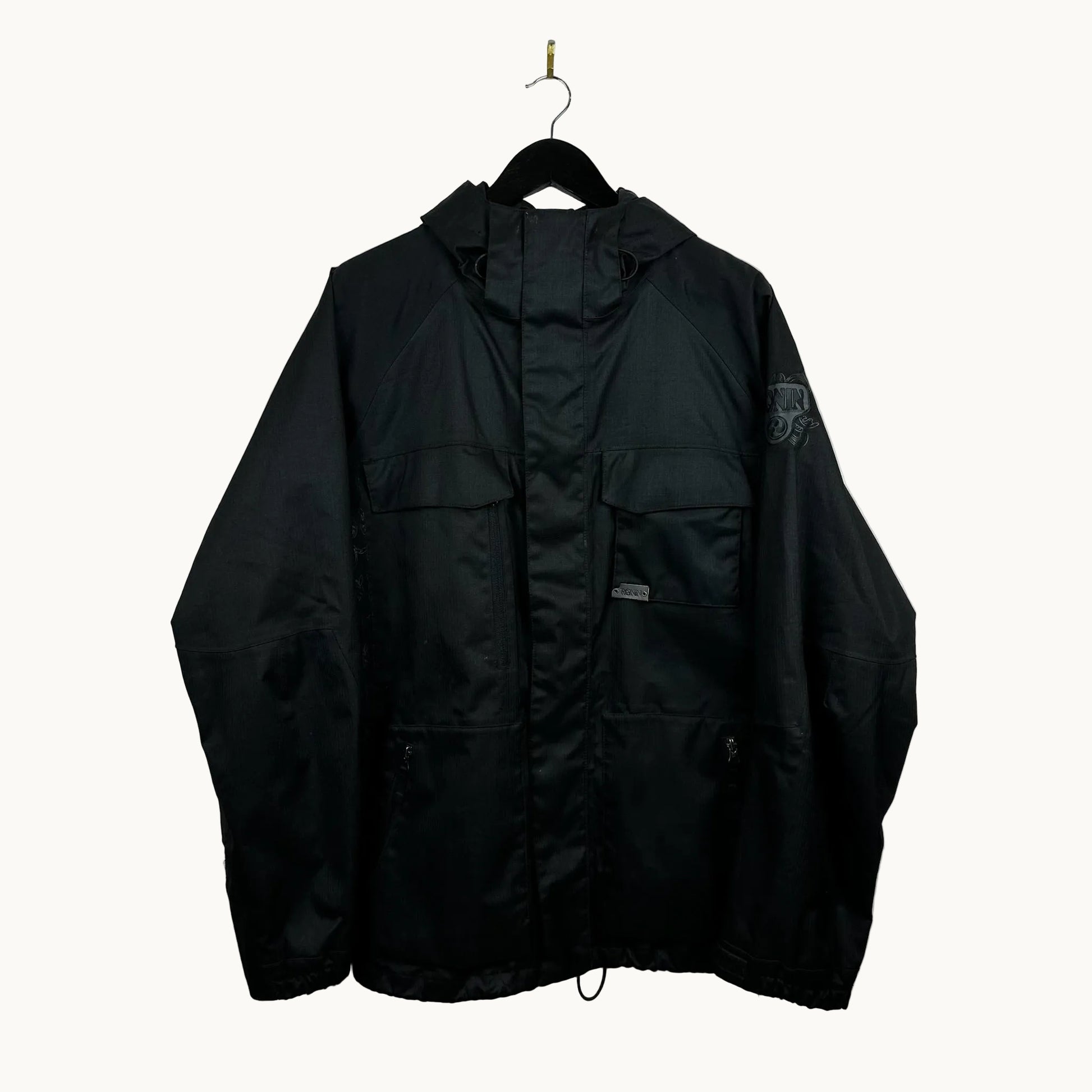 Black burton ronin jacket hanging on a hook against a white wall