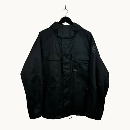 Black burton ronin jacket hanging on a hook against a white wall