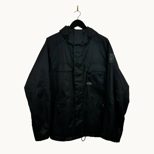 Black burton ronin jacket hanging on a hook against a white wall